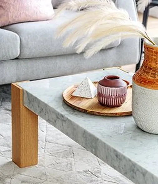Marble and oak coffee table styled with ceramics — case goods care and warranty booklet