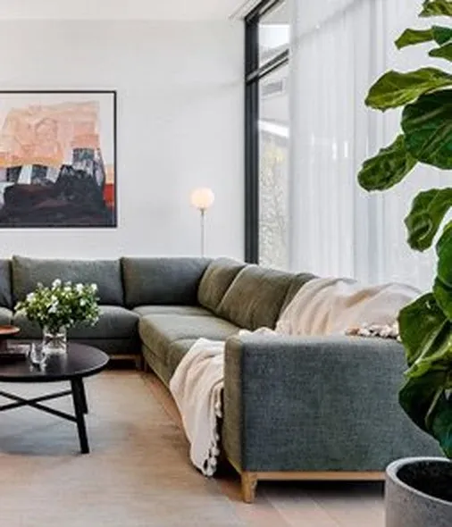 Green fabric modular lounge in a light-filled living room — lounge care and warranty booklet